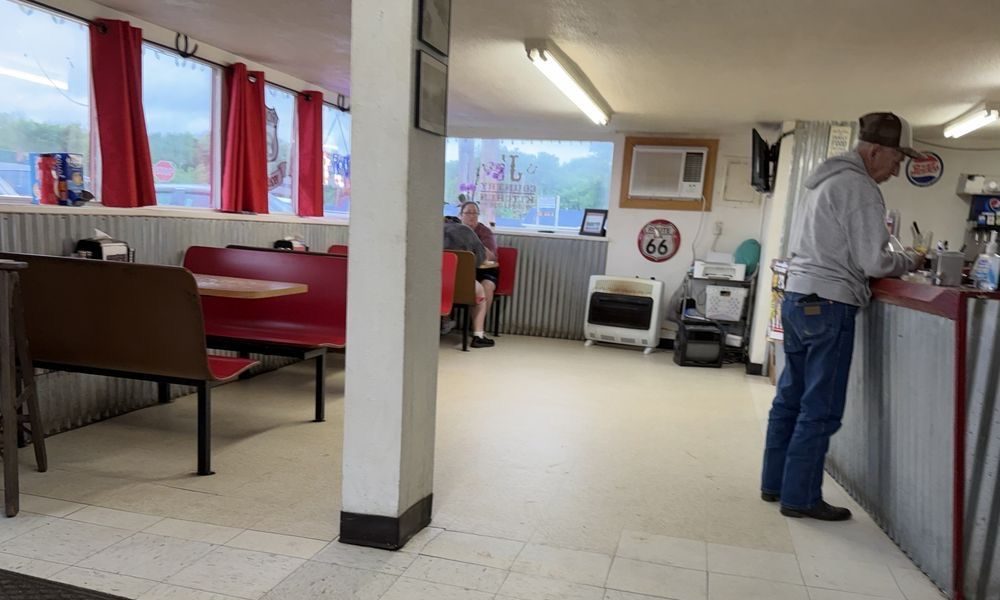 The dining room: red booths, red curtains, tin wainscoting, a Route 66 sign and a regular at the counter